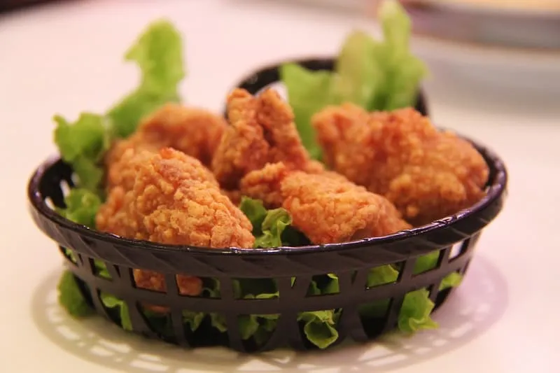 ayam goreng tepung dan sayur di dalam wadah hitam