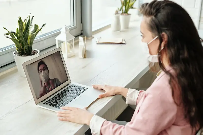 seorang wanita sedang mengajar lewat laptop