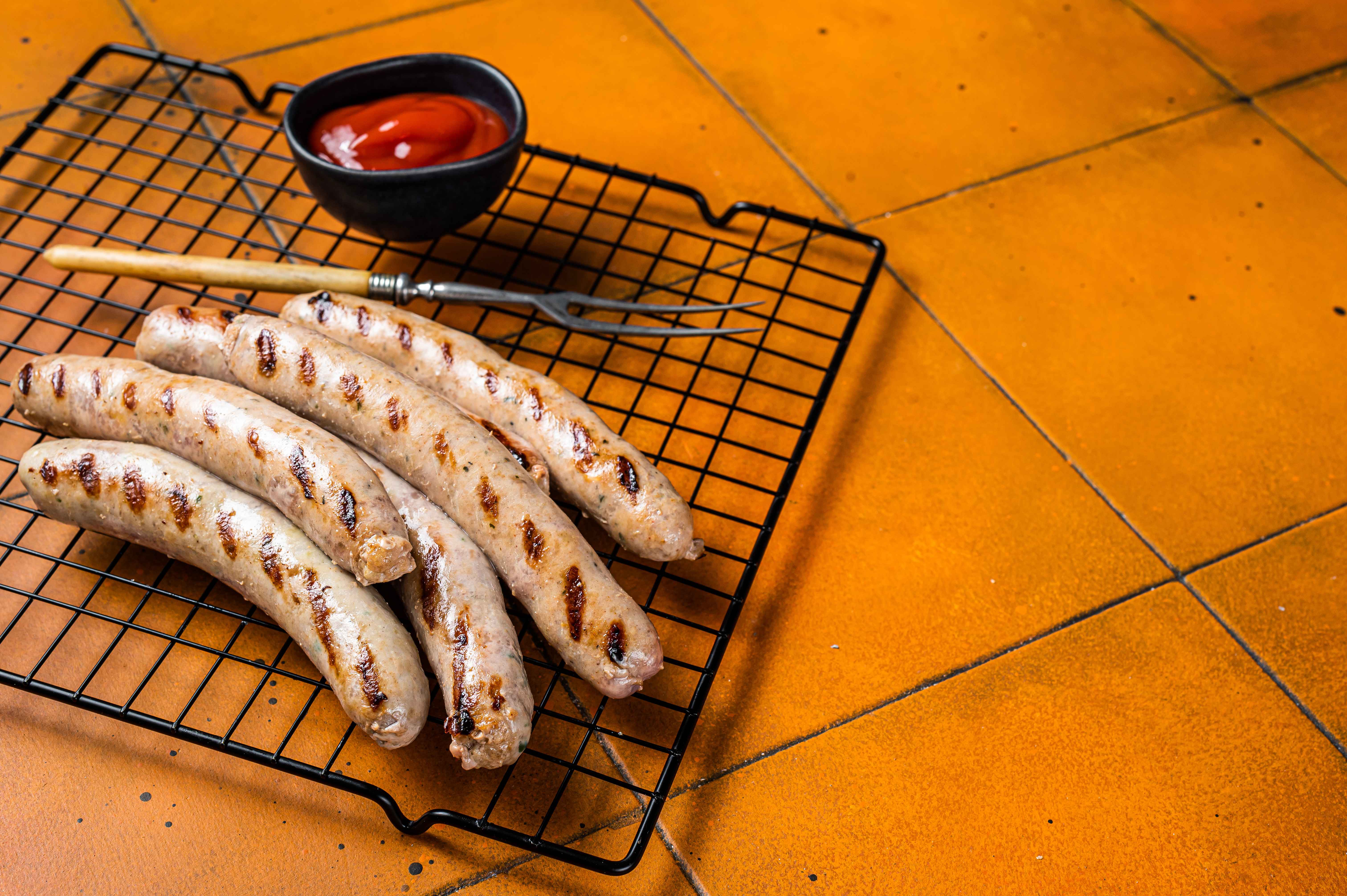 grilled-beef-sausages-from-a-bbq-orange-backgroun